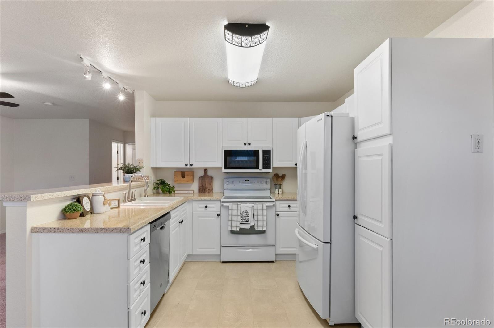 12734 Eudora Drive Thornton, CO 80241 - Photo 11 of 49 a kitchen with a sink stainless steel appliances and cabinets