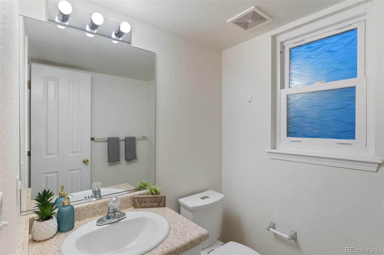 12734 Eudora Drive Thornton, CO 80241 - Photo 18 of 49 a bathroom with a toilet a sink and mirror