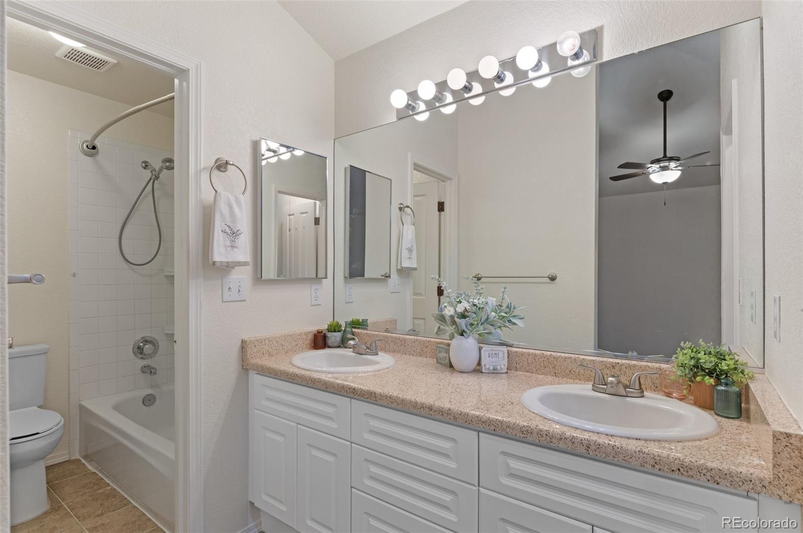 12734 Eudora Drive Thornton, CO 80241 - Photo 24 of 49 a bathroom with a granite countertop sink a toilet and a mirror