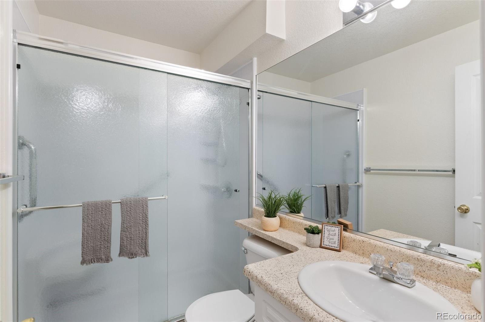 12734 Eudora Drive Thornton, CO 80241 - Photo 27 of 49 a bathroom with a sink and mirror