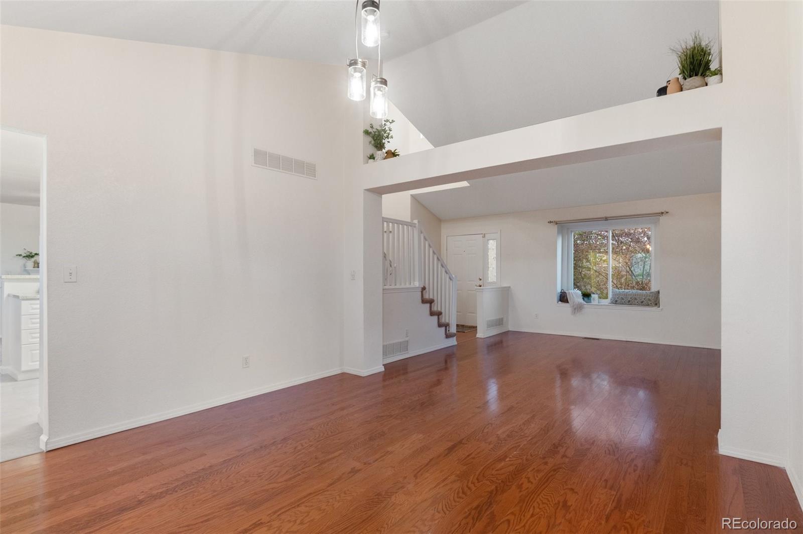 12734 Eudora Drive Thornton, CO 80241 - Photo 10 of 49 an empty room with wooden floor and windows