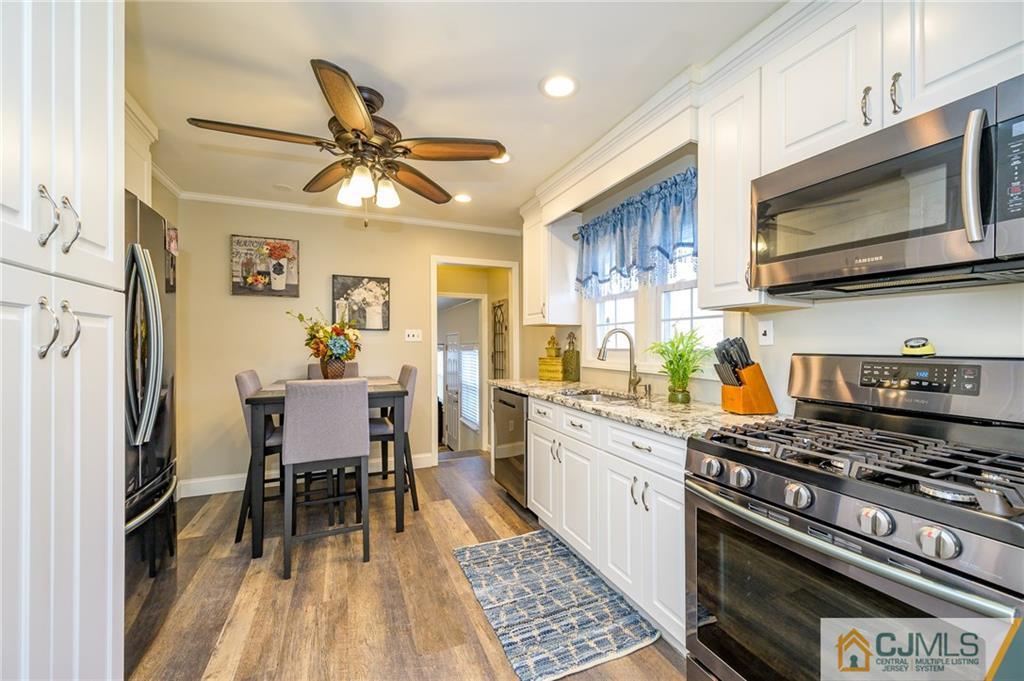 14 Sine Road Edison, NJ 08817 - Photo 11 of 33 a kitchen with stainless steel appliances a white table and chairs in it