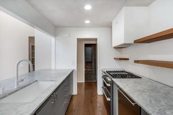 a living room with stainless steel appliances kitchen island a stove and a refrigerator