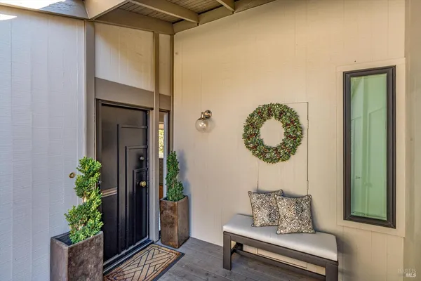 a bench sitting in front of a house with a potted plant