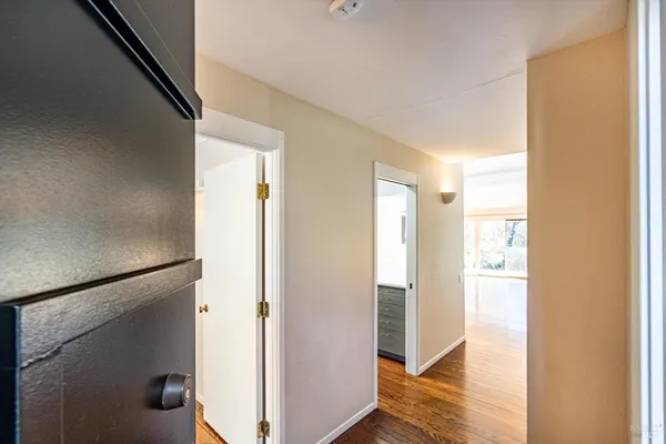 a view of a hallway with wooden floor