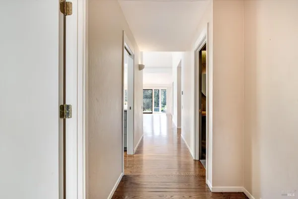 a view of a hallway with wooden floor and staircase