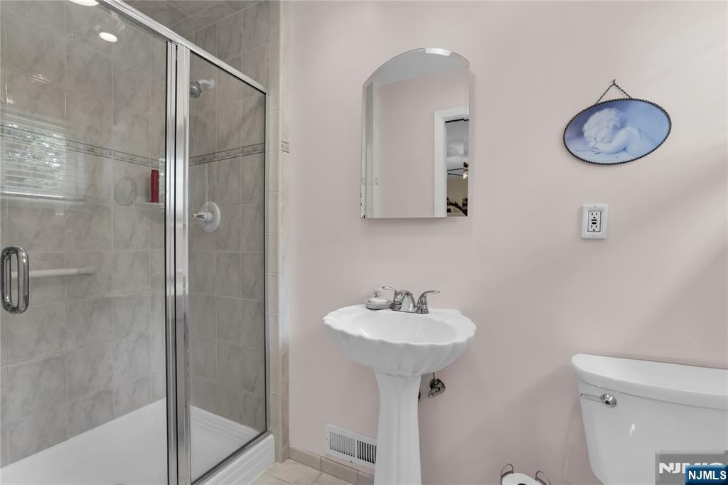 23 Ridge Court Cedar Grove, NJ 07009 - Photo 22 of 37 a bathroom with a toilet a sink and mirror