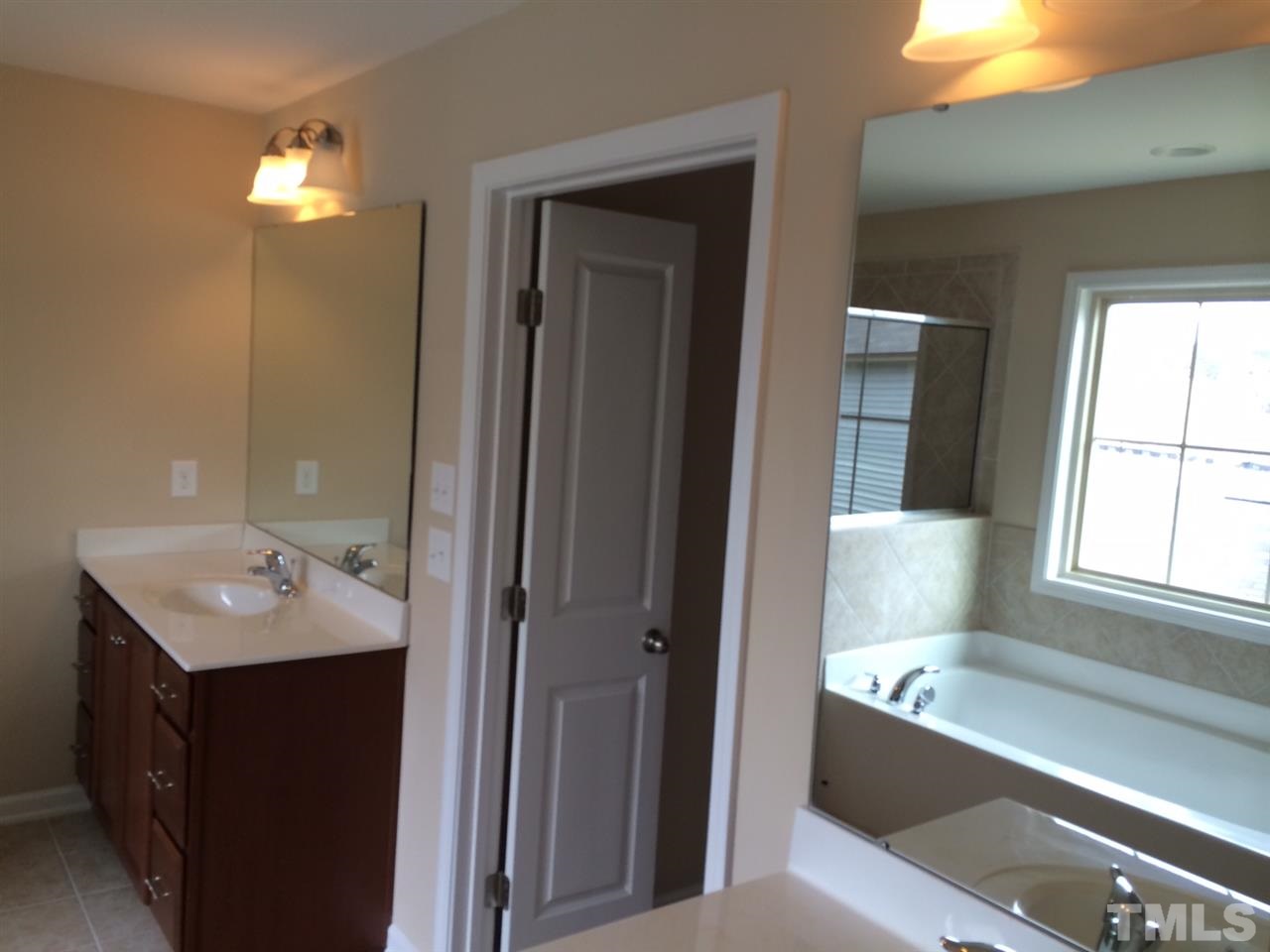 7609 Channery Way Raleigh, NC 27616 - Photo 16 of 25 a bathroom with a tub sink and mirror
