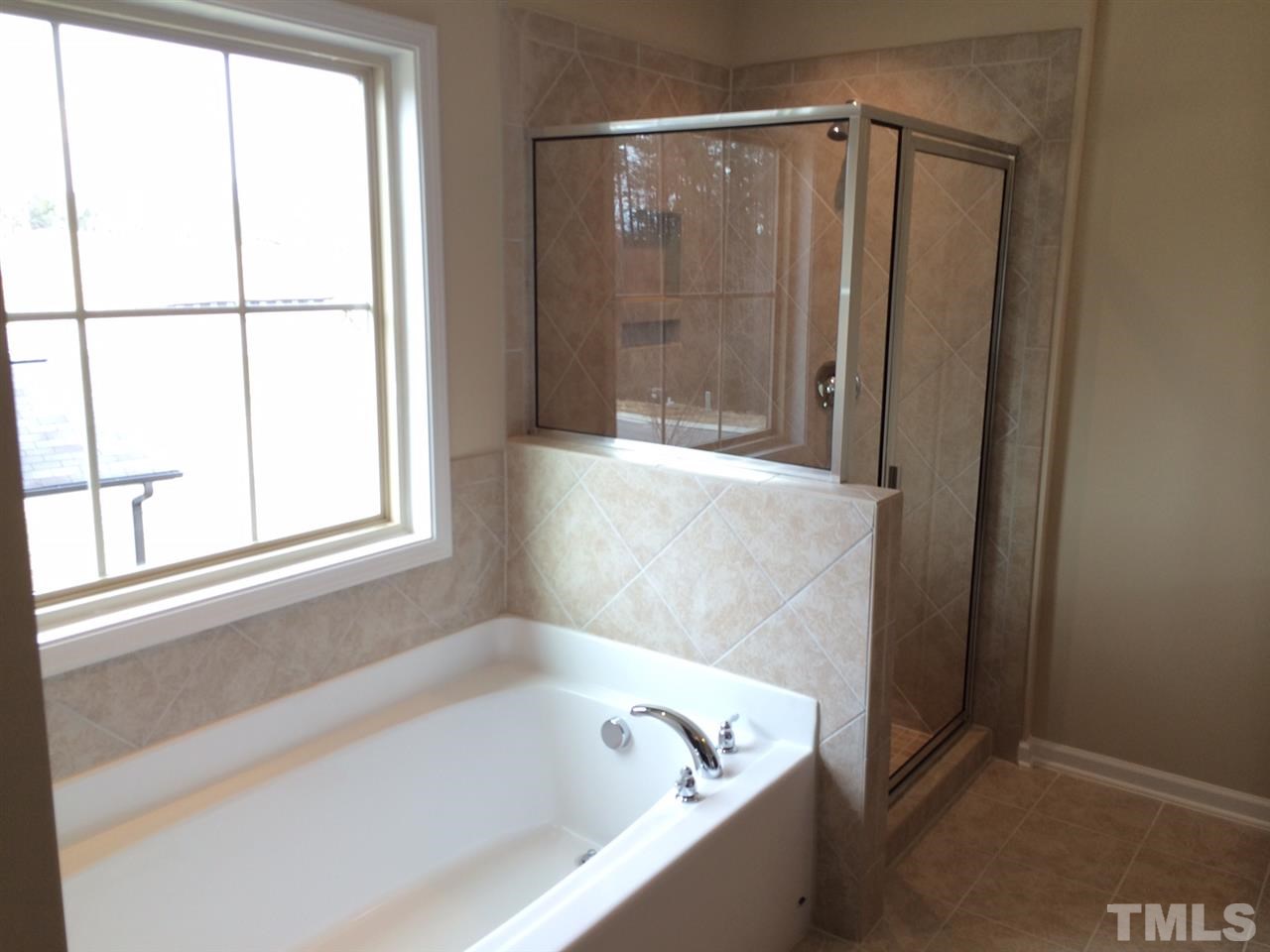 7609 Channery Way Raleigh, NC 27616 - Photo 17 of 25 a bathroom with a bathtub and a shower