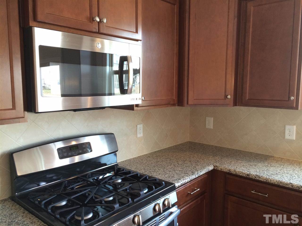 7609 Channery Way Raleigh, NC 27616 - Photo 4 of 25 a kitchen with a stove and a microwave