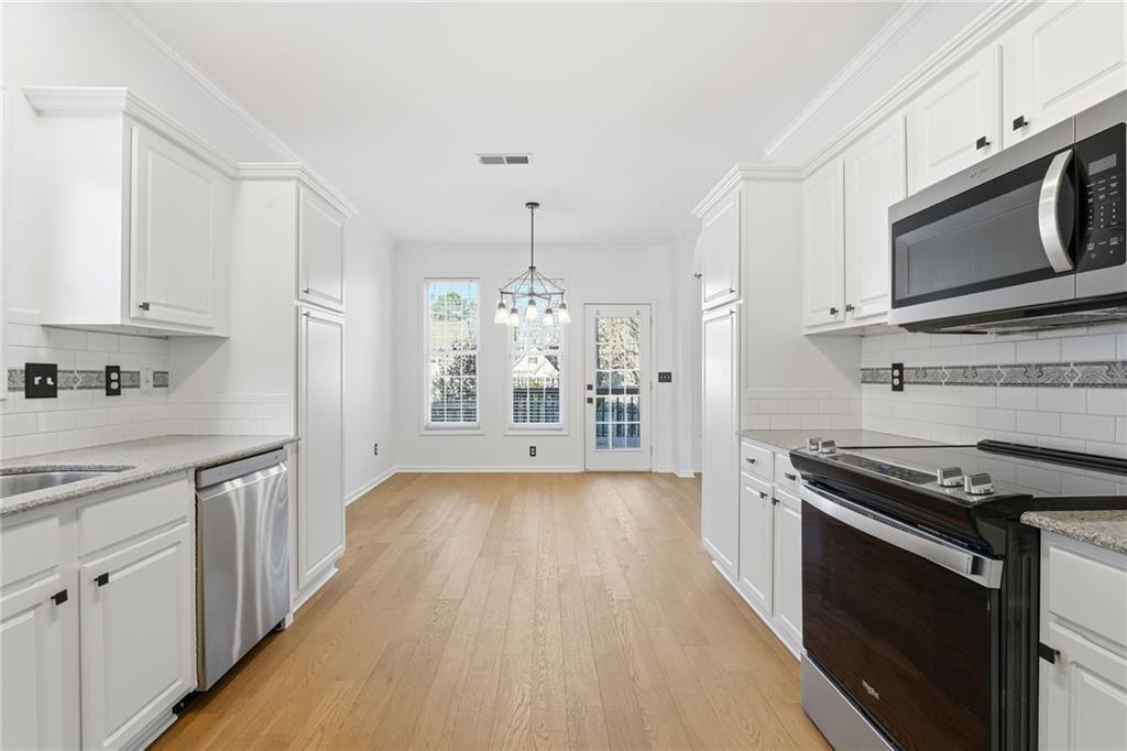 205 Towne Ridge Drive Woodstock, GA 30188 - Photo 19 of 56 a kitchen with stainless steel appliances a stove microwave and cabinets
