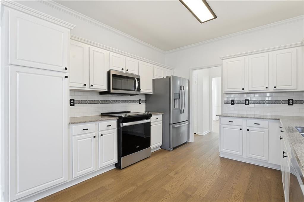 205 Towne Ridge Drive Woodstock, GA 30188 - Photo 22 of 56 a kitchen with stainless steel appliances white cabinets and a refrigerator