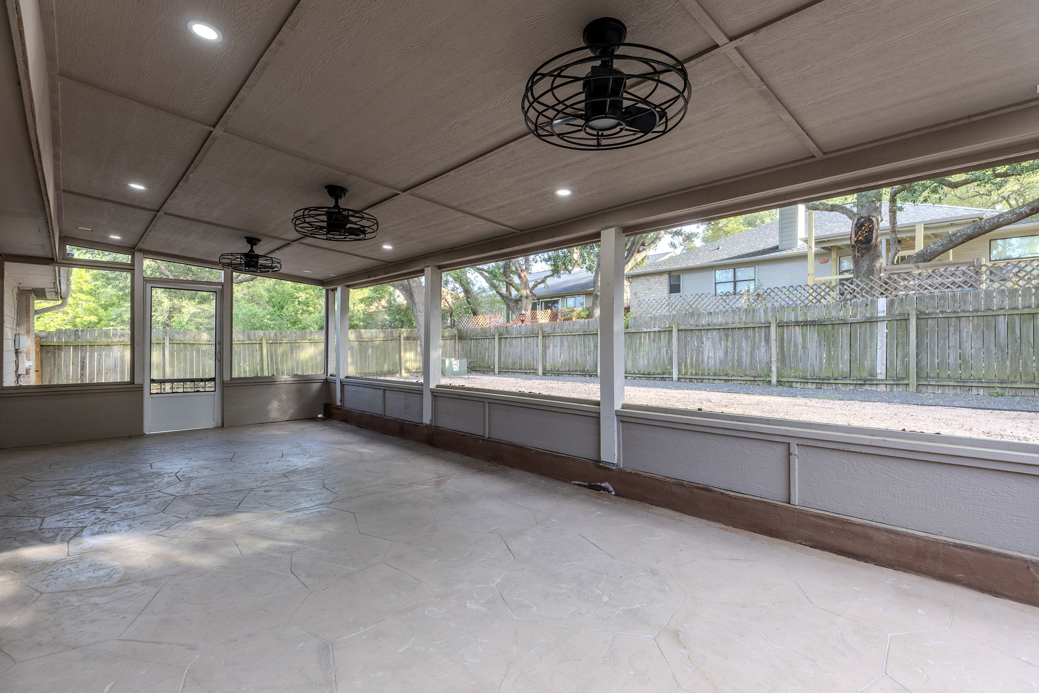 2409 Water Well Lane Austin, TX 78728 - Photo 20 of 22 Expansive screened porch with stamped concrete flooring, multiple ceiling fans with integrated lighting, recessed ceiling lights, and a full-height screen door