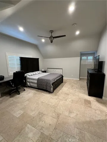 a bedroom with a bed a lamp and a flat screen tv