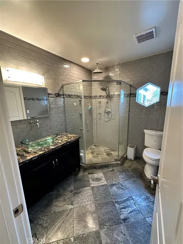 a bathroom with a granite countertop sink toilet and shower