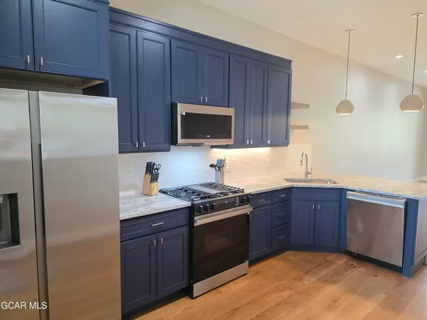 a kitchen with stainless steel appliances granite countertop wooden cabinets a stove top oven a sink and dishwasher
