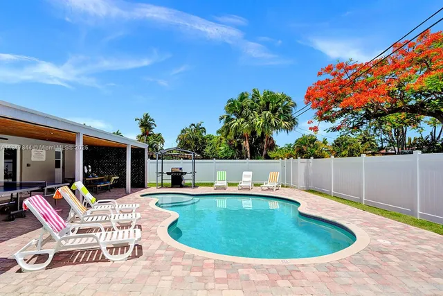 a swimming pool with outdoor seating and yard