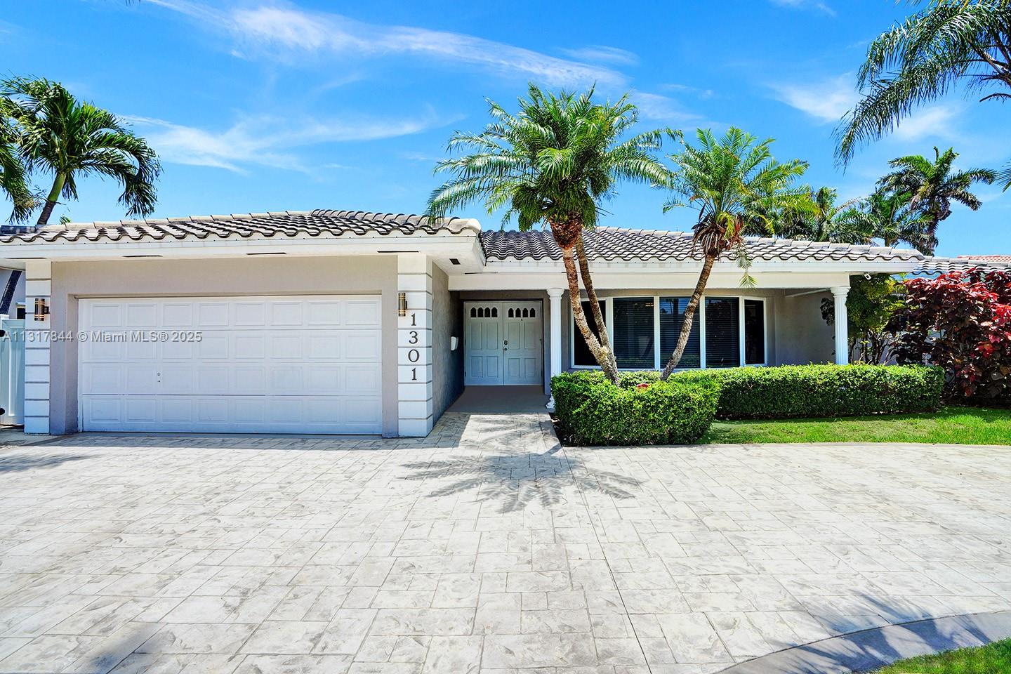 1301 Rodman Street Hollywood, FL 33019 - Photo 12 of 48 a front view of a house with a garden and palm trees