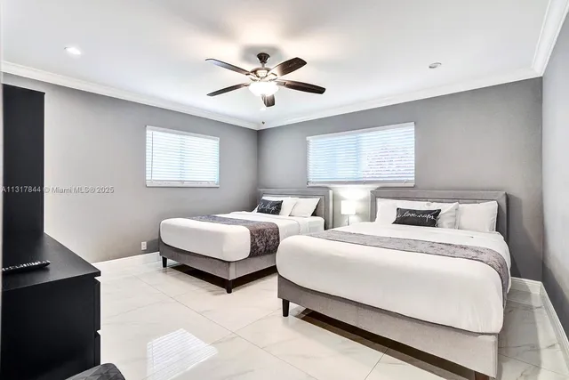 a bedroom with two bed and a chandelier