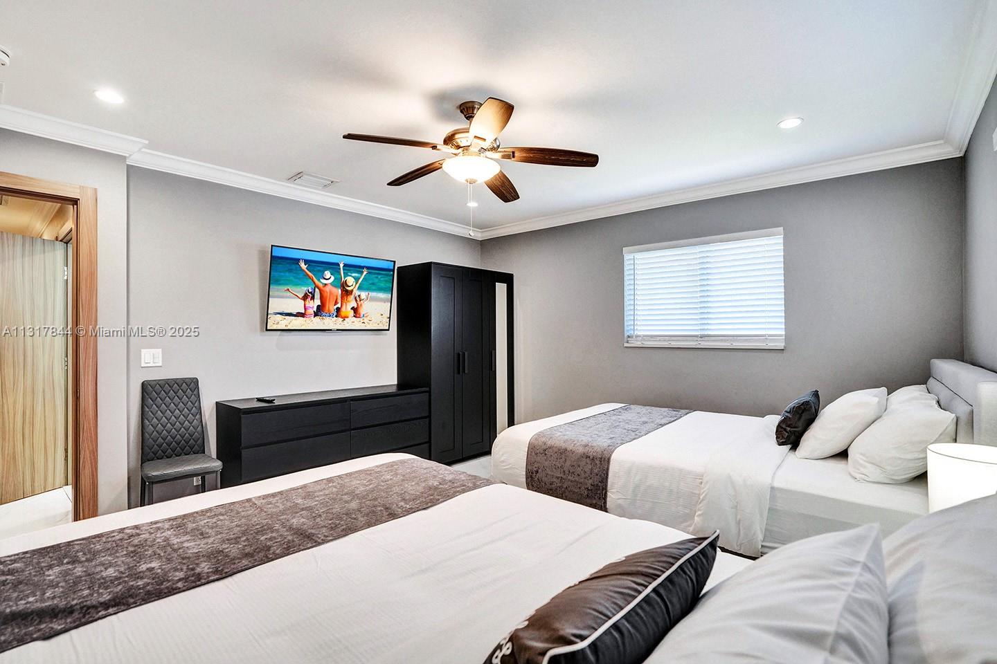 1301 Rodman Street Hollywood, FL 33019 - Photo 14 of 48 a bedroom with two bed and a chandelier