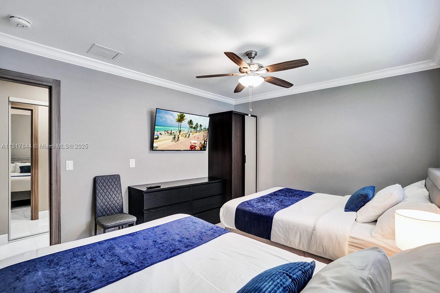 1301 Rodman Street Hollywood, FL 33019 - Photo 17 of 48 a bedroom with two beds and a chandelier