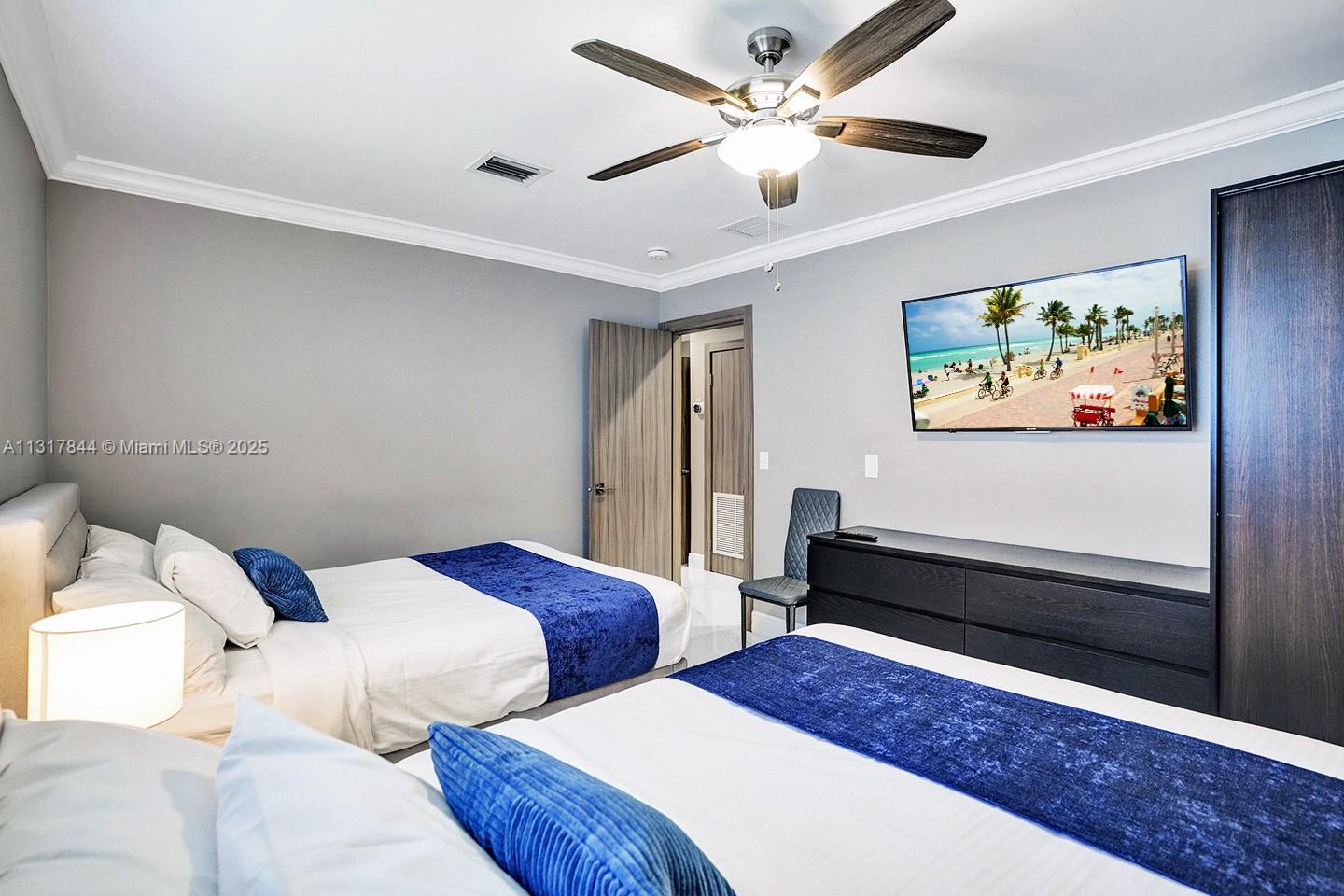 1301 Rodman Street Hollywood, FL 33019 - Photo 18 of 48 a bedroom with two beds and a chandelier