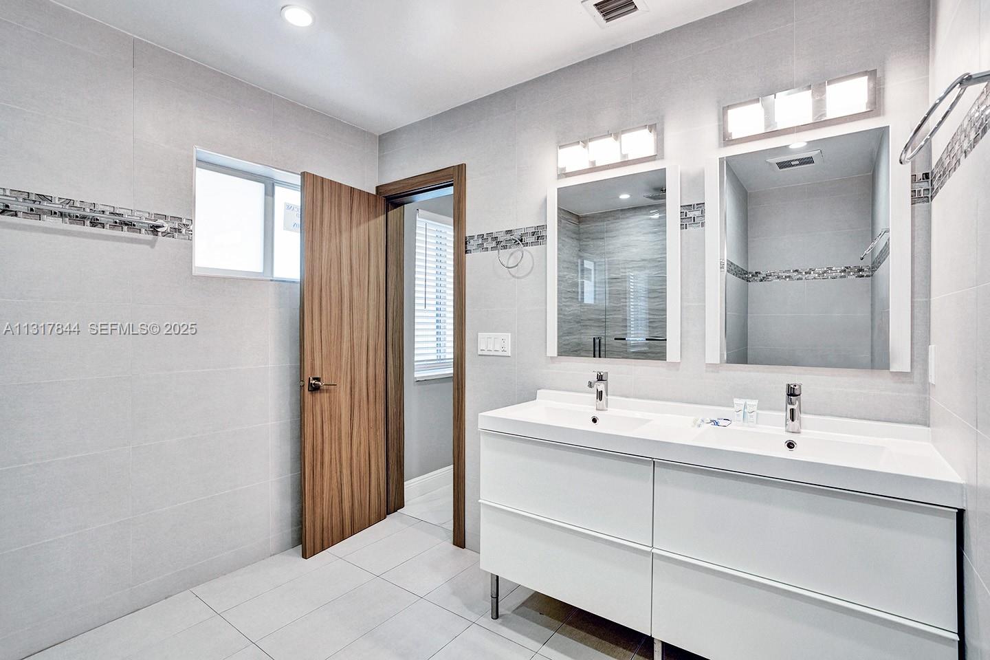1301 Rodman Street Hollywood, FL 33019 - Photo 22 of 48 a bathroom with a double vanity sink mirror and double
