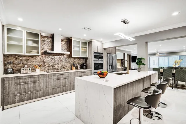 a kitchen with stainless steel appliances a sink a stove a microwave a refrigerator and cabinets