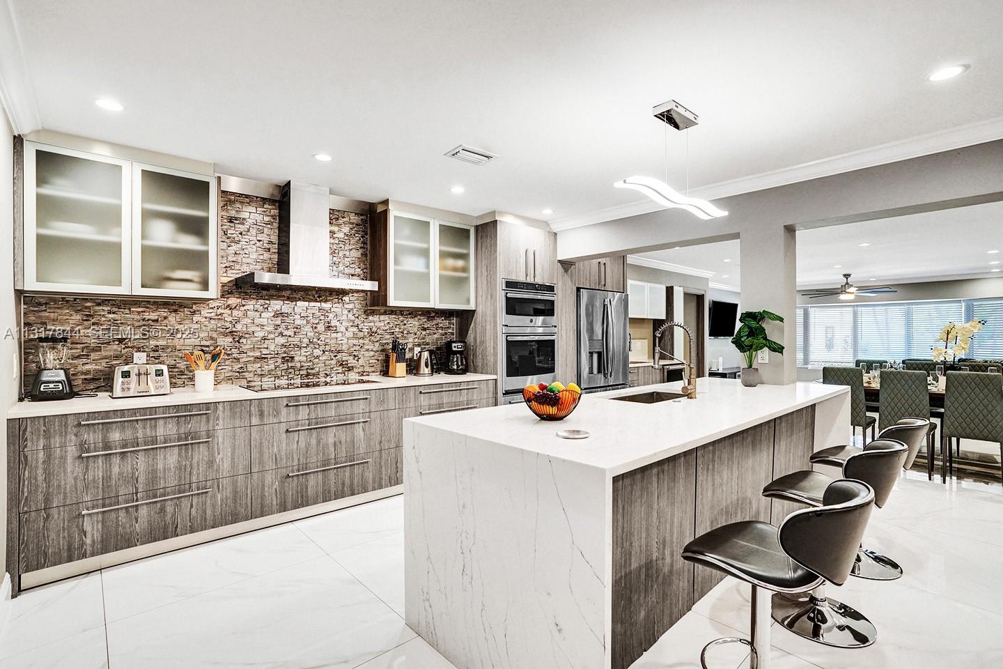 1301 Rodman Street Hollywood, FL 33019 - Photo 27 of 48 a kitchen with stainless steel appliances kitchen island granite countertop a sink and cabinets
