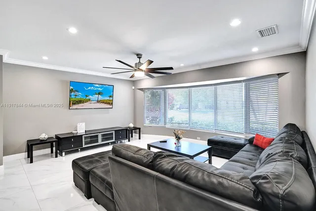 a living room with furniture a wooden floor and a window
