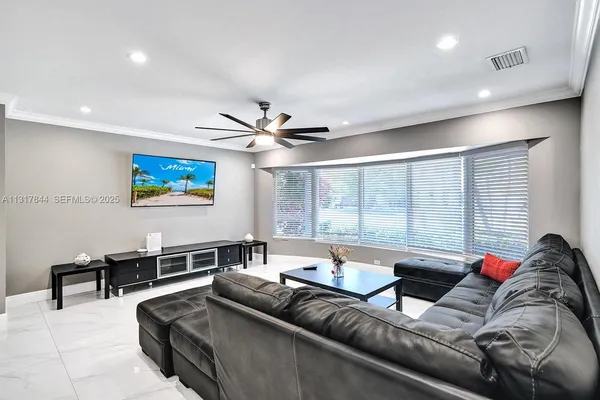 a living room with furniture a wooden floor and a window
