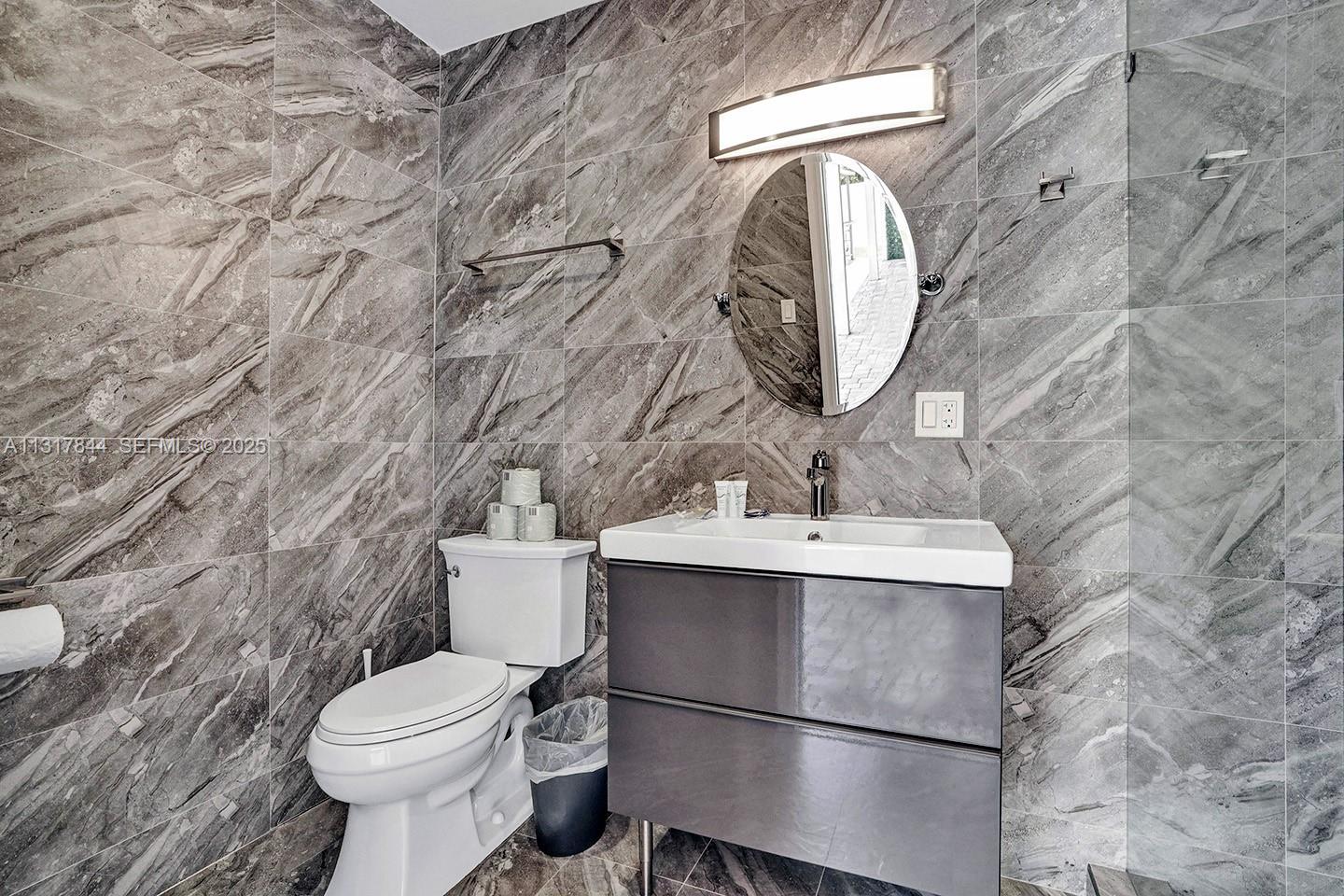 1301 Rodman Street Hollywood, FL 33019 - Photo 43 of 48 a bathroom with a sink toilet and mirror