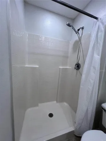 a bedroom with a bed window and a mirror