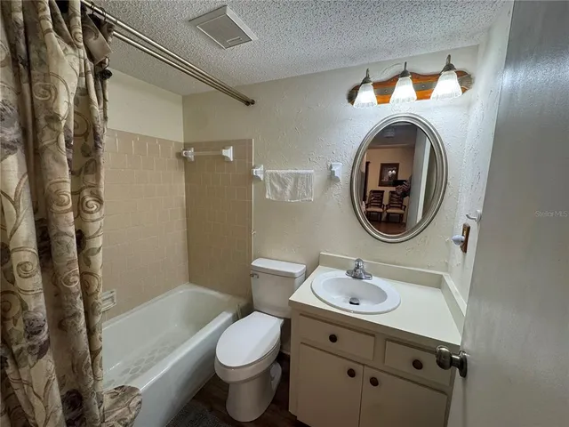 a bathroom with a sink a mirror a toilet and a shower