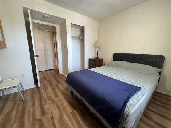 a bedroom with a bed and wooden floor