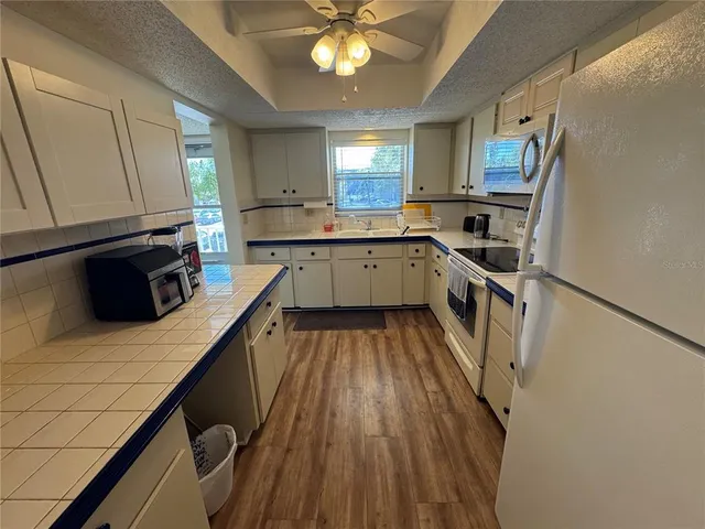 a kitchen with a sink appliances wooden floor and cabinets