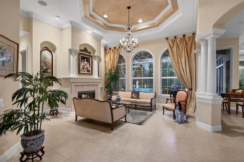 7815 Mathern Court Lakewood Ranch, FL 34202 - Photo 14 of 55 a living room with furniture a fireplace and a chandelier