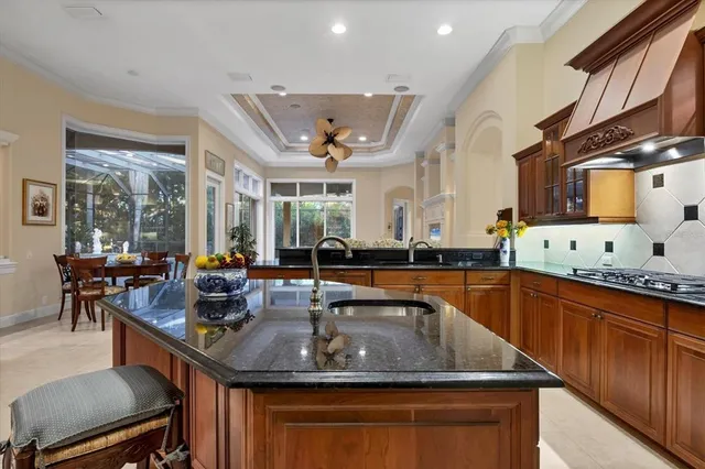 a kitchen with stainless steel appliances granite countertop a sink a stove and a wooden cabinets