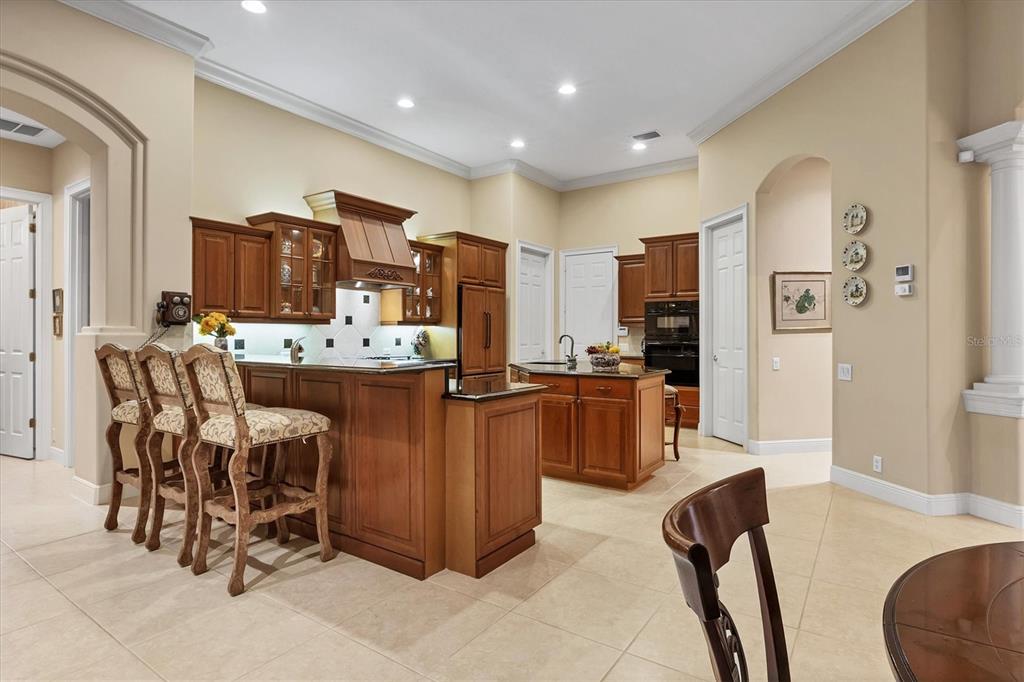 7815 Mathern Court Lakewood Ranch, FL 34202 - Photo 18 of 55 a kitchen with stainless steel appliances kitchen island granite countertop a refrigerator and a stove top oven