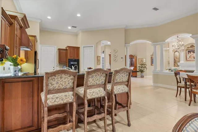 a living room with furniture a flat screen tv and kitchen area