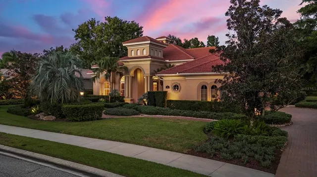 a view of a white house with a yard and potted plants