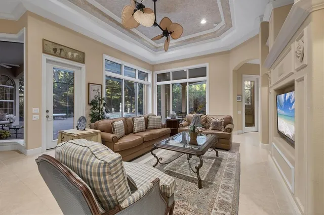 a living room with furniture a flat screen tv and a large window