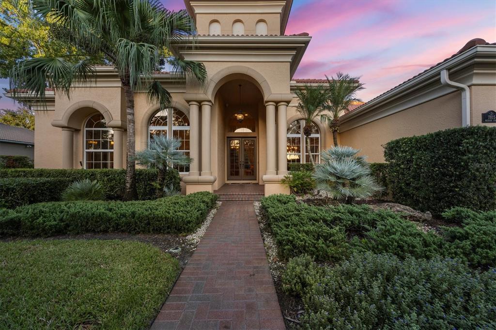 7815 Mathern Court Lakewood Ranch, FL 34202 - Photo 3 of 55 a view of a house with brick walls and a small yard