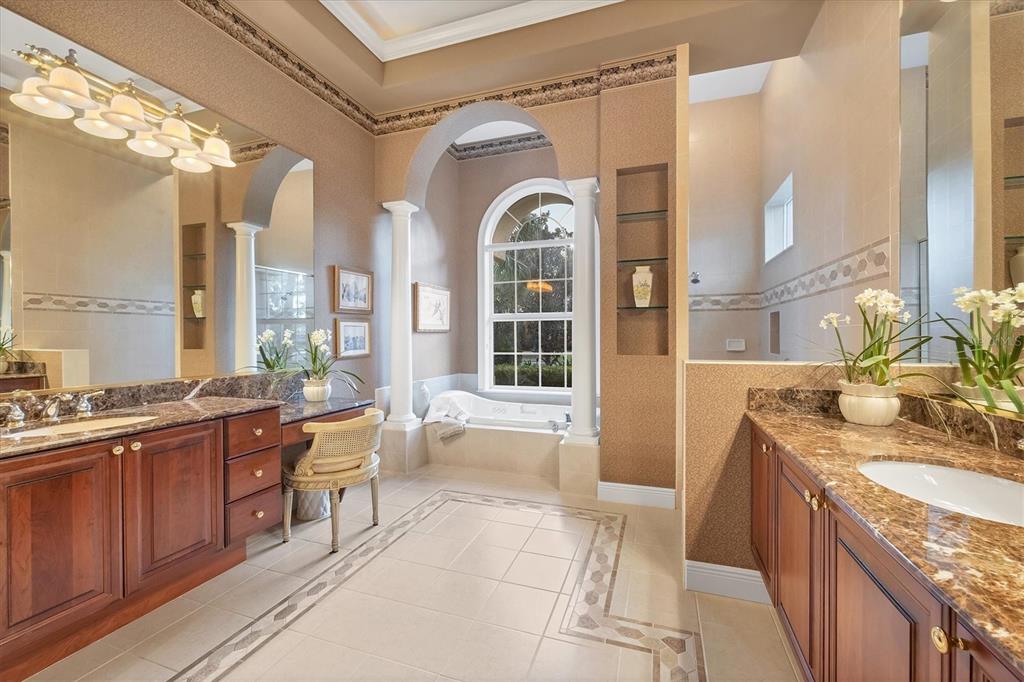7815 Mathern Court Lakewood Ranch, FL 34202 - Photo 31 of 55 a large bathroom with a granite countertop tub a double vanity sink a mirror and a large window
