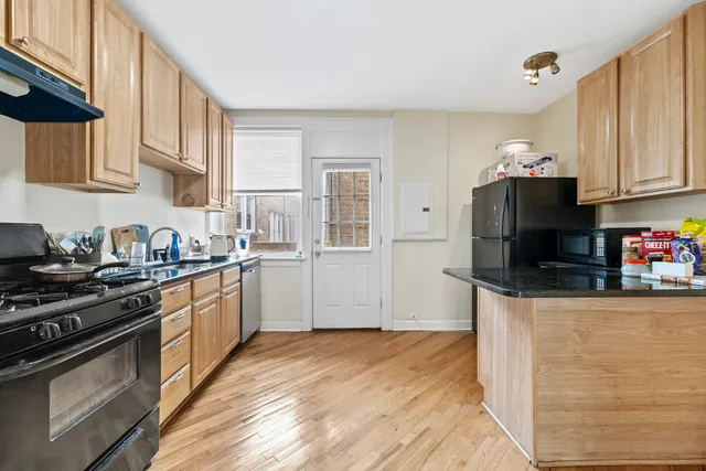 a kitchen with stainless steel appliances granite countertop a stove a sink and a refrigerator
