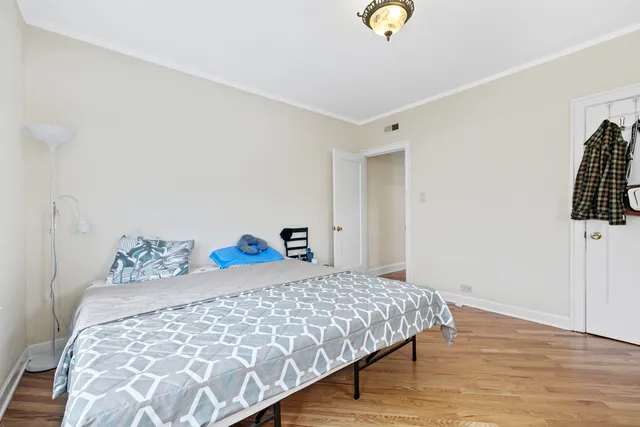 a bedroom with a bed and a lamp on the dresser