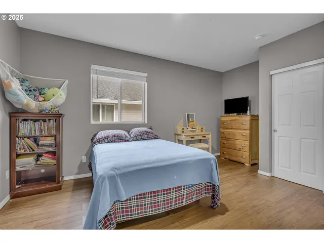 a view of a bedroom with wooden floor and closet