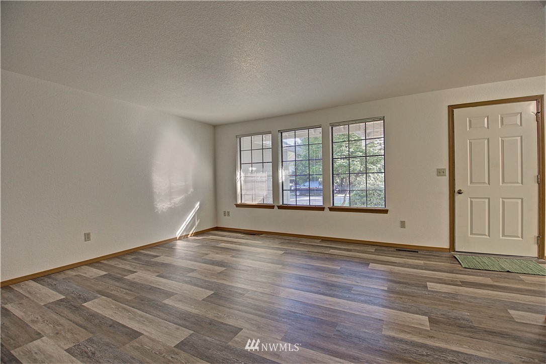 1820 Diamond Loop Southeast Lacey, WA 98503 - Photo 3 of 17 an empty room with wooden floor and windows