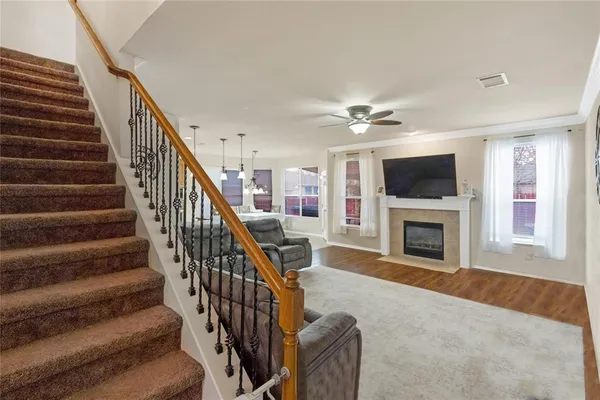 a view of a livingroom with an empty kitchen and a fireplace