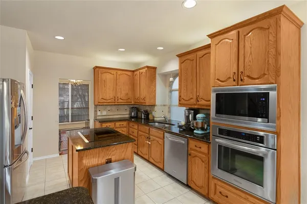 a kitchen with stainless steel appliances a stove a sink a microwave and cabinets